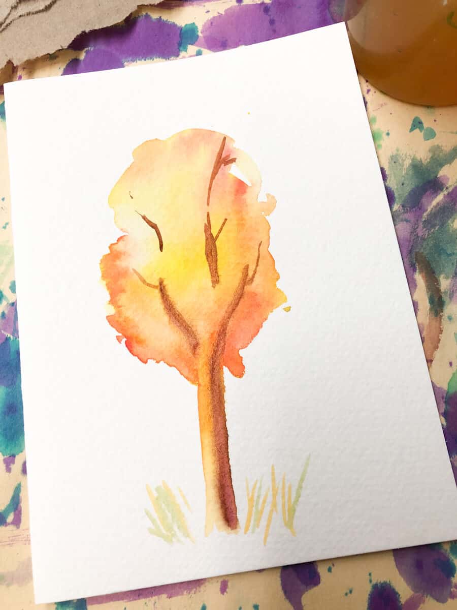 watercolor branches being added to fall tree painting in watercolor paint.