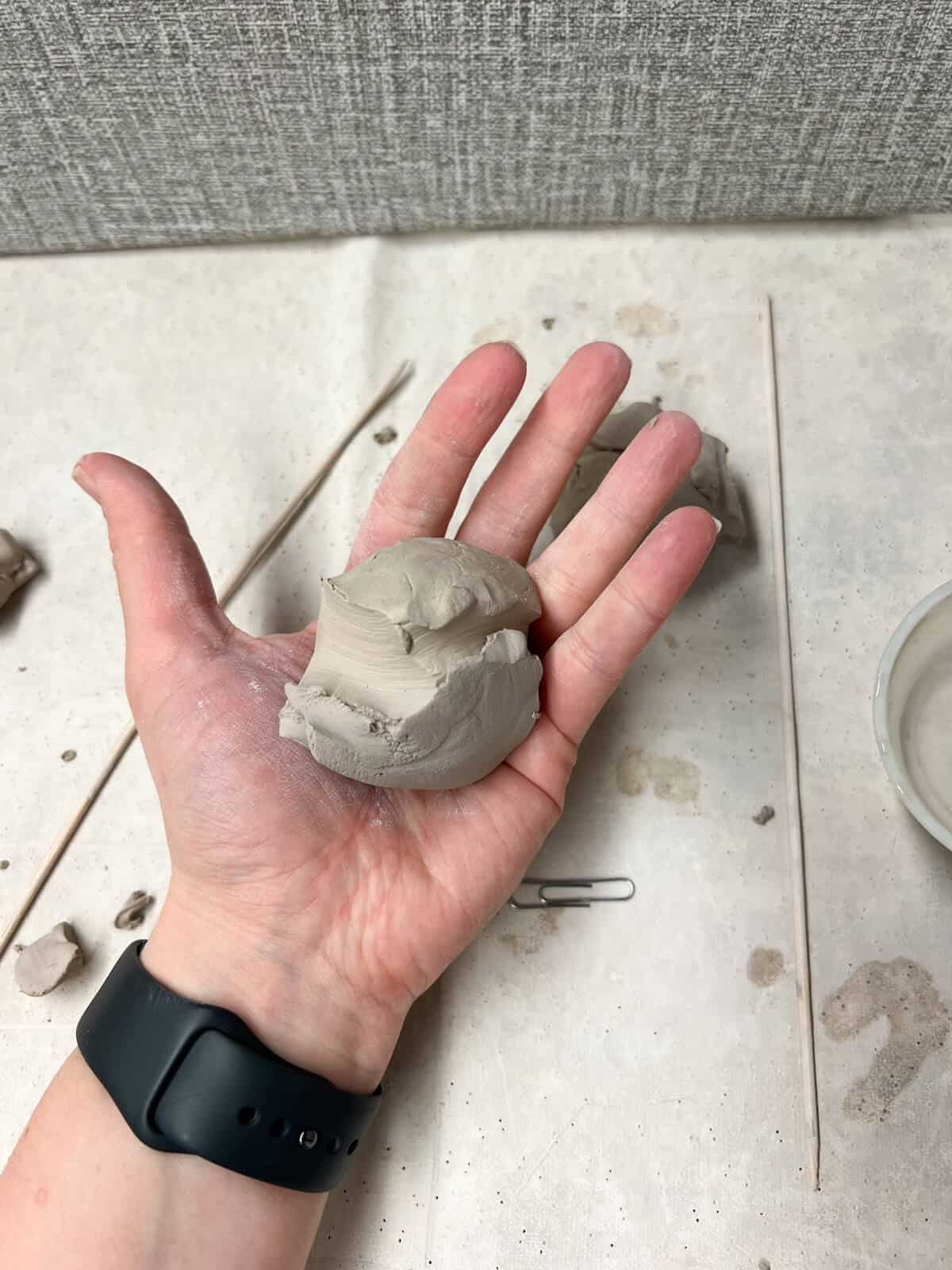 clay ball in hand before starting clay project for kids.