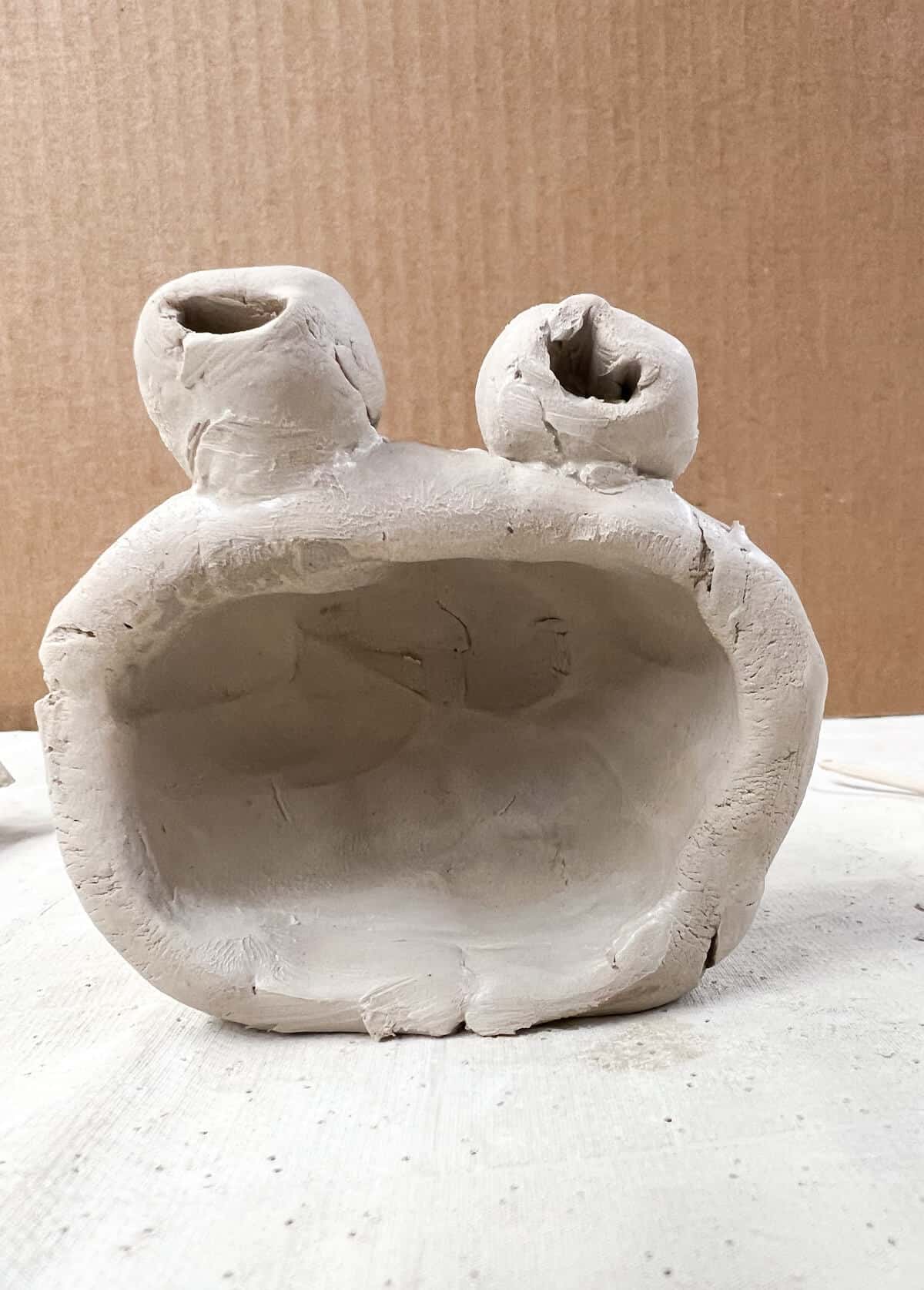 clay monster eyes attached to pinch pot head.