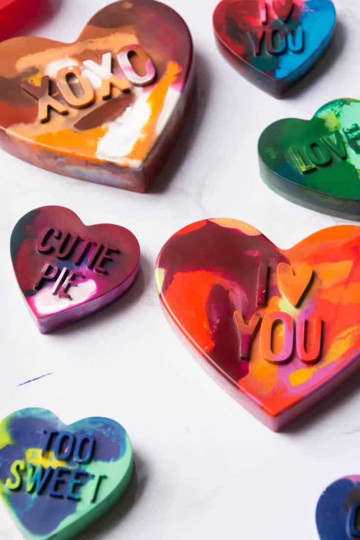DIY crayons melted in oven in silicone heart molds with different sayings on them.