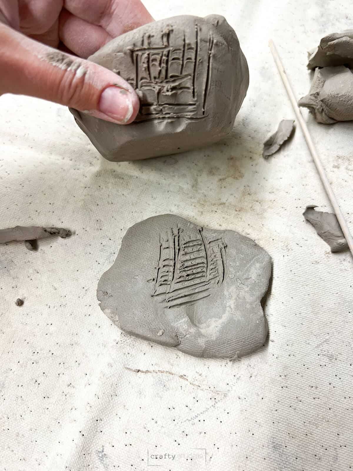 clay pinch pot and one piece of clay with score lines on them