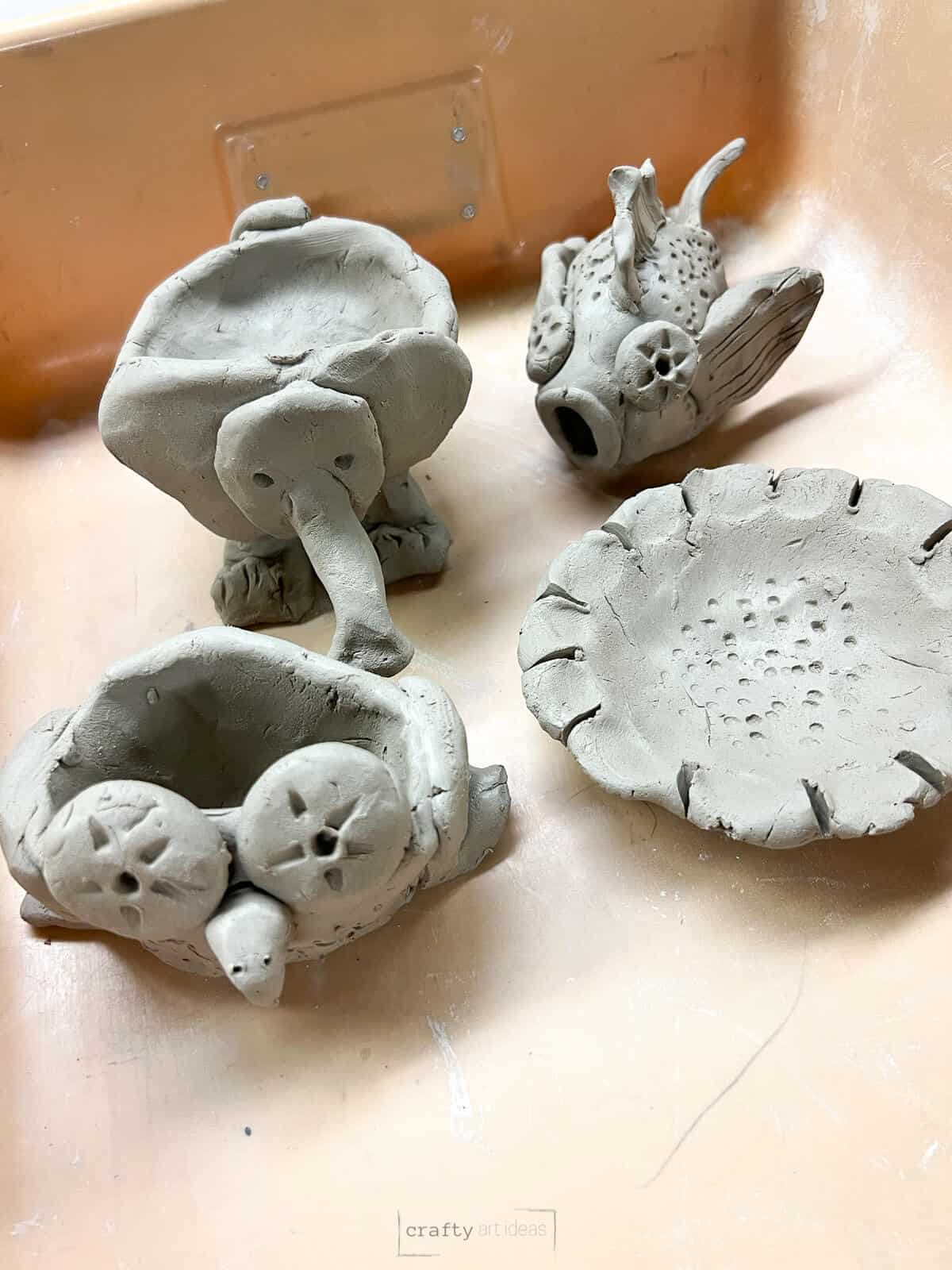 examples of pinch pot clay ideas for kids with a flower, fish, owl and elephant.
