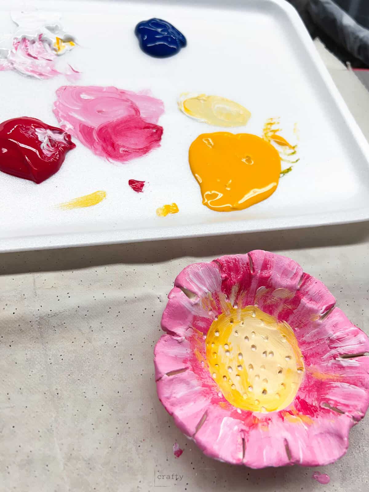 yellow and pink painted clay flower pinch pot art project.