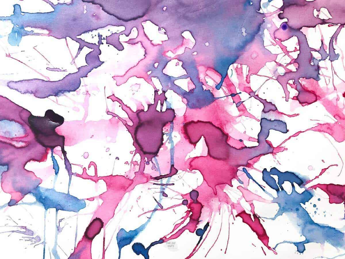 abstract straw painting done by children with pink, purple and teal watercolor paint.