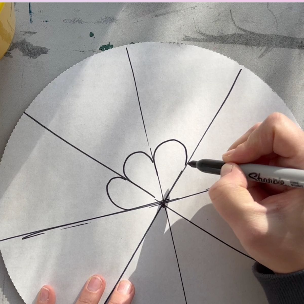 hand drawing designs on cardboard circle.