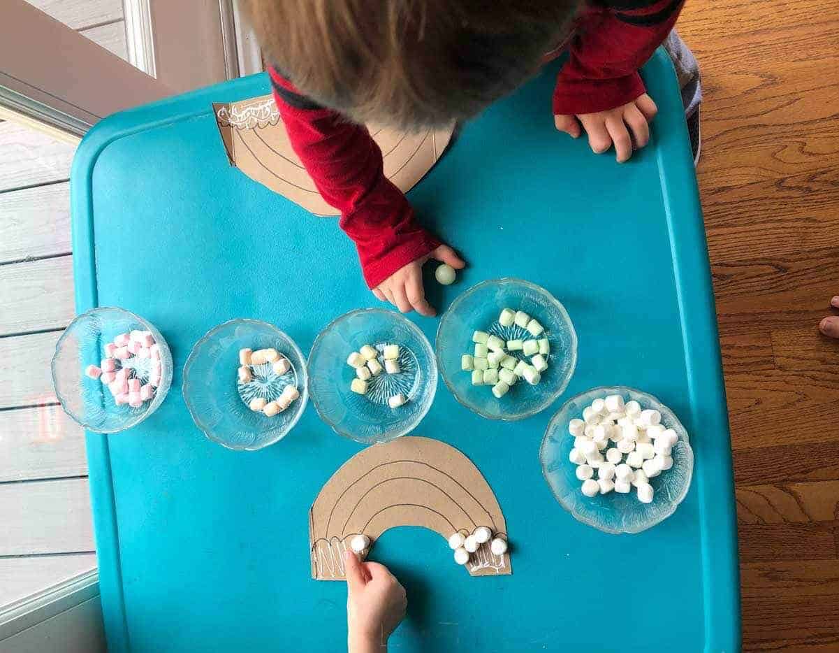 preschoolers sorting marshmallows in small bowls.