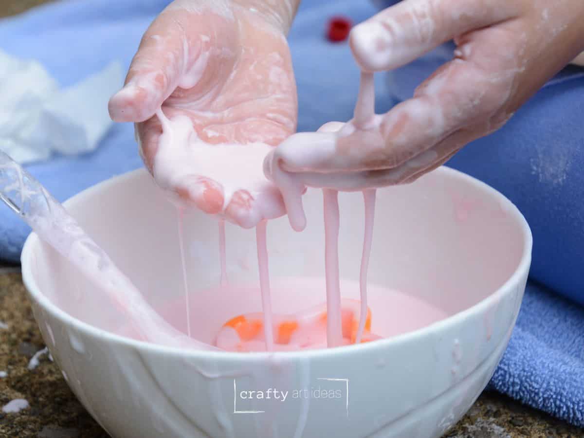 child's hands playing with oobleck made from baby powder.