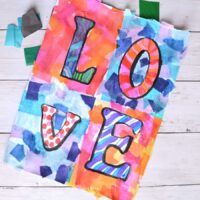 tissue paper on paper with marker spelling love.