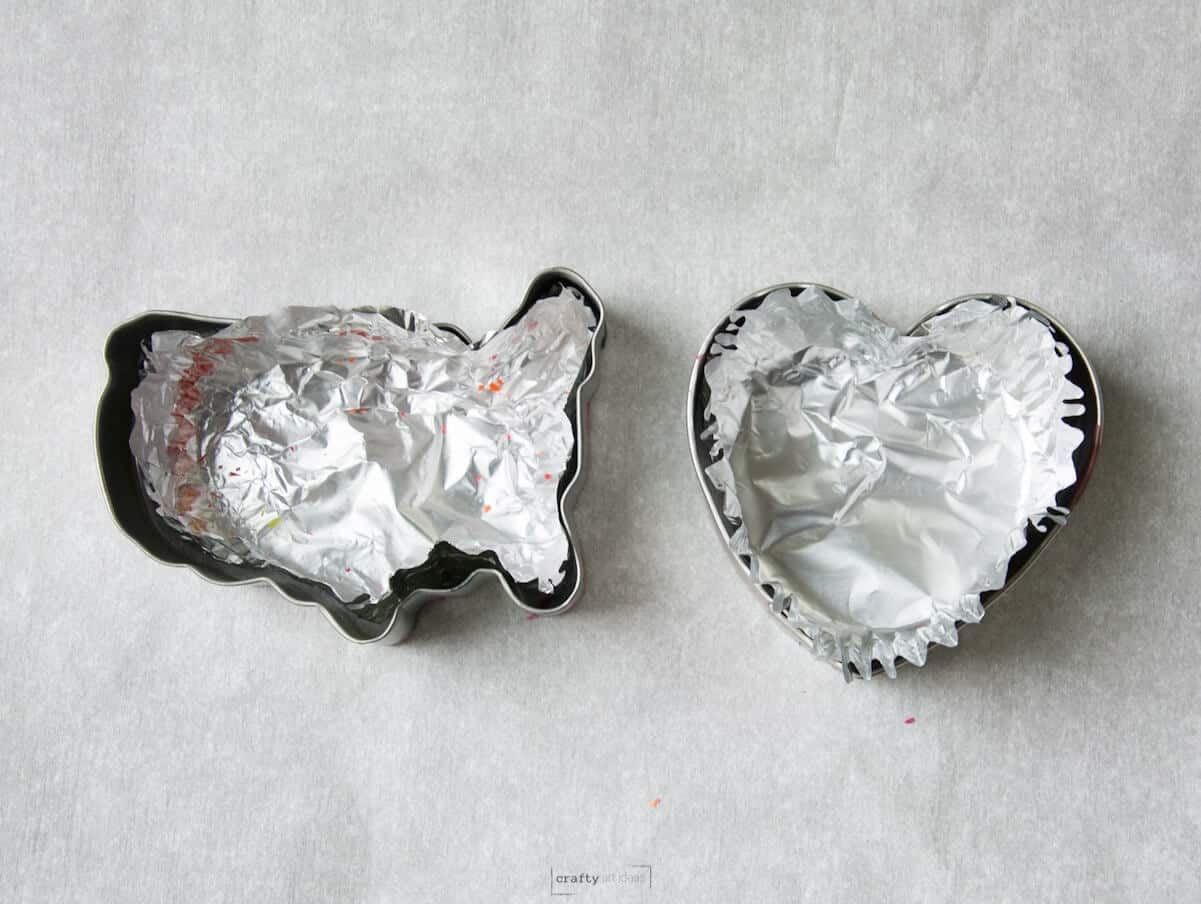 foil cupcake liner in two cookie cutters on parchment paper.