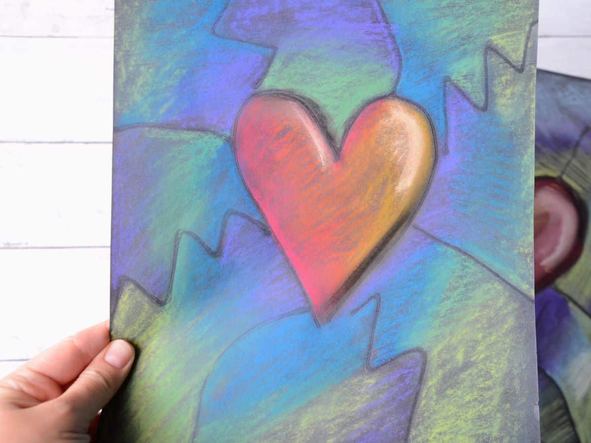 hand holding heart chalk pastel art project for kids.