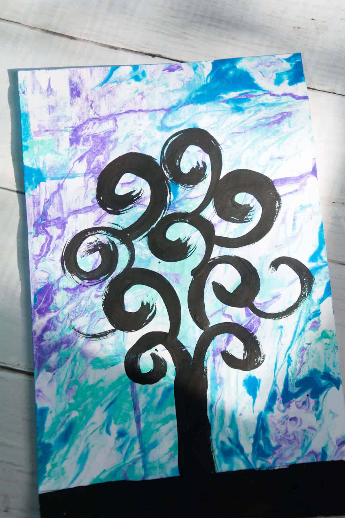 black painted swirly tree on blue, green and purple background.