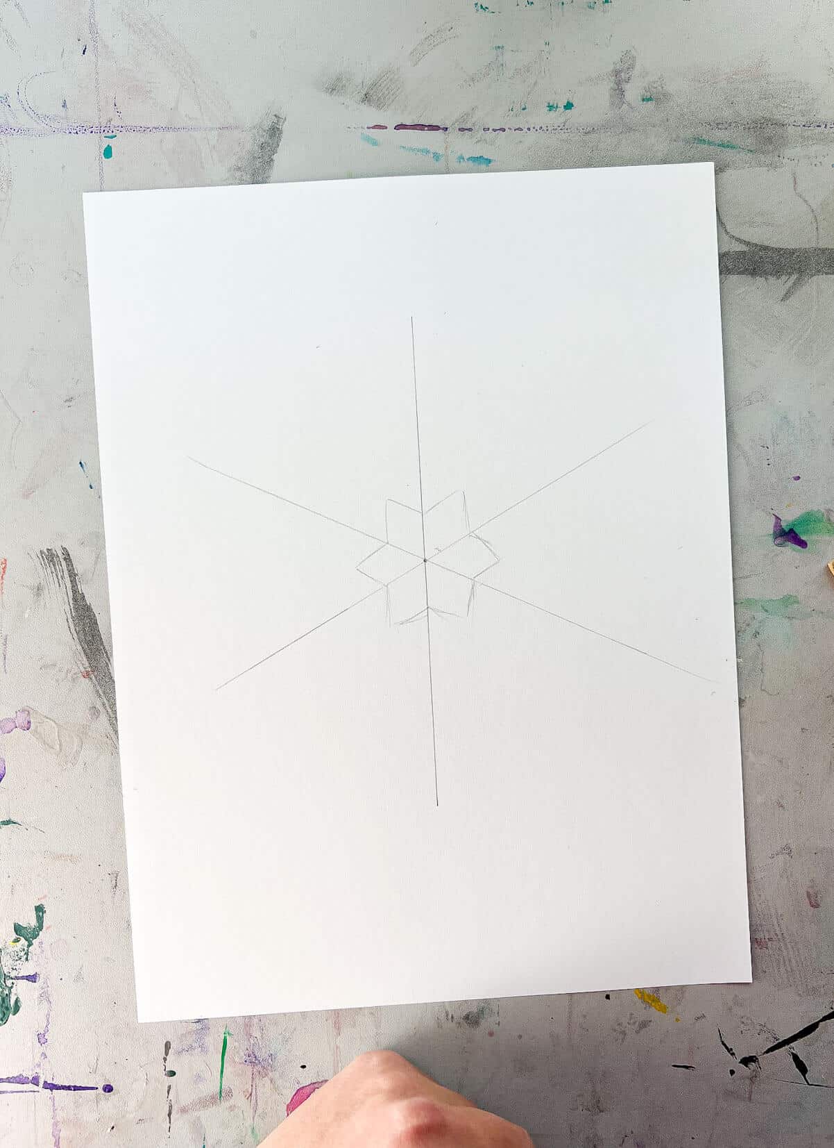 center of snowflake sketch lightly on white paper.