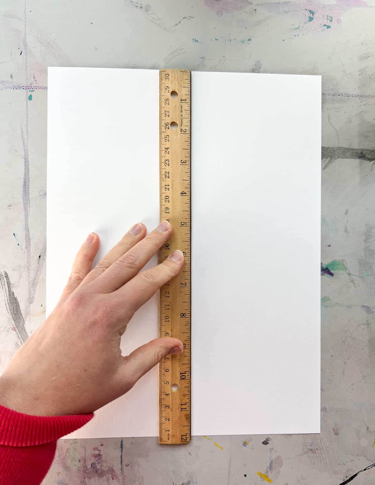 hand holding ruler to make vertical line.