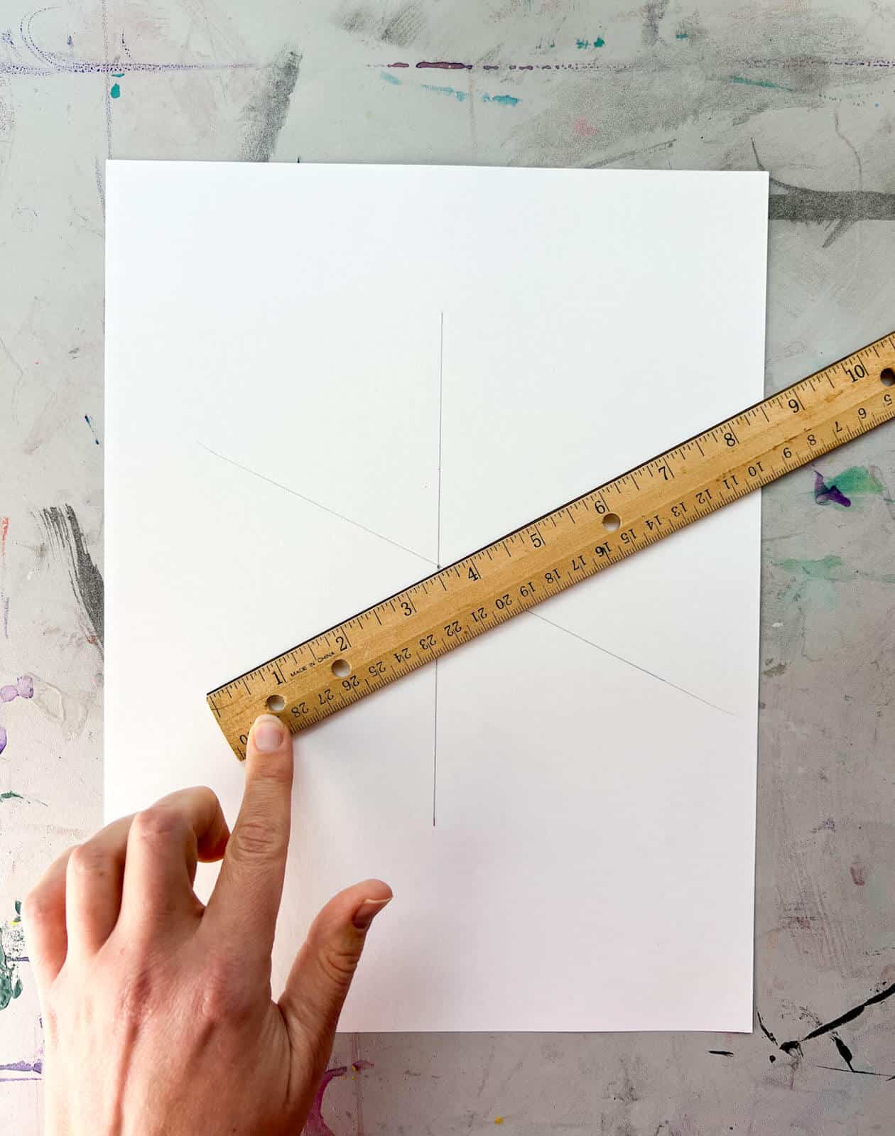 hand holding ruler to draw diagonal line.