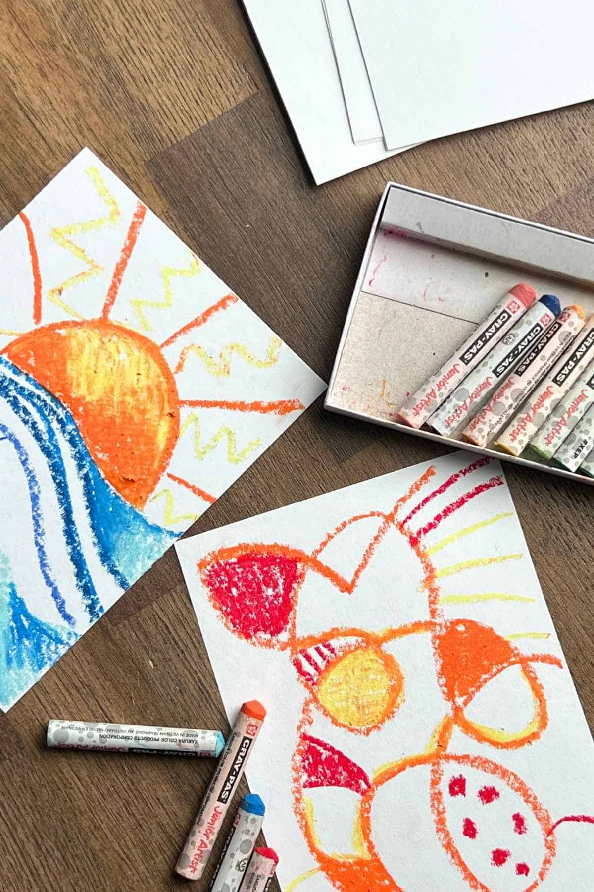 sunset and abstract oil pastel drawings on white paper.