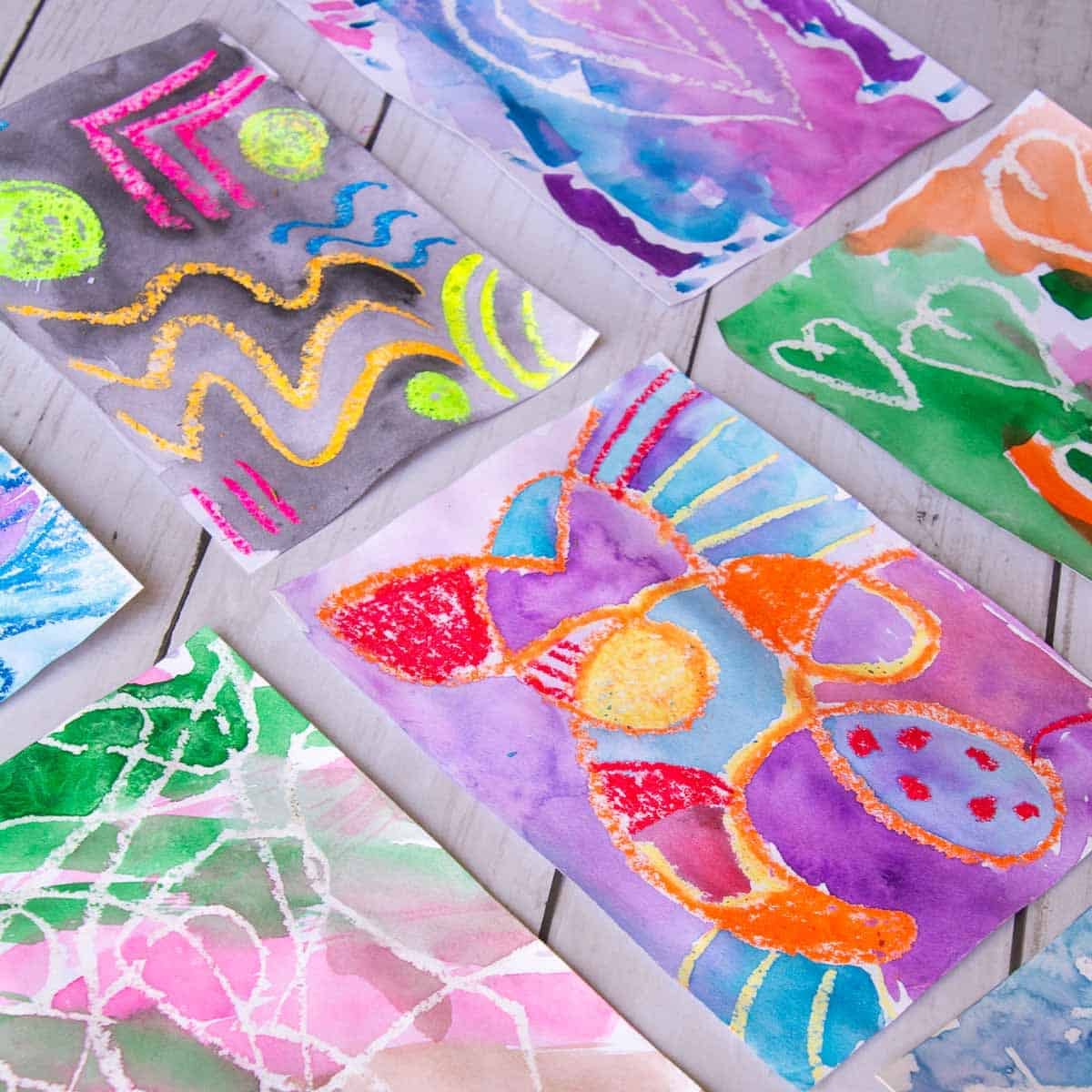 oil pastel and watercolor paintings on a table.