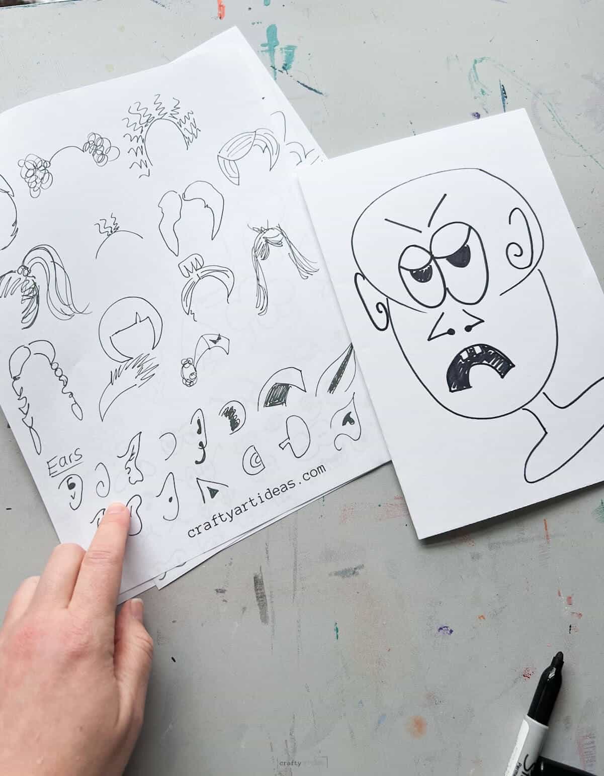 hand pointing to ears with cartoon head drawing with same ears.