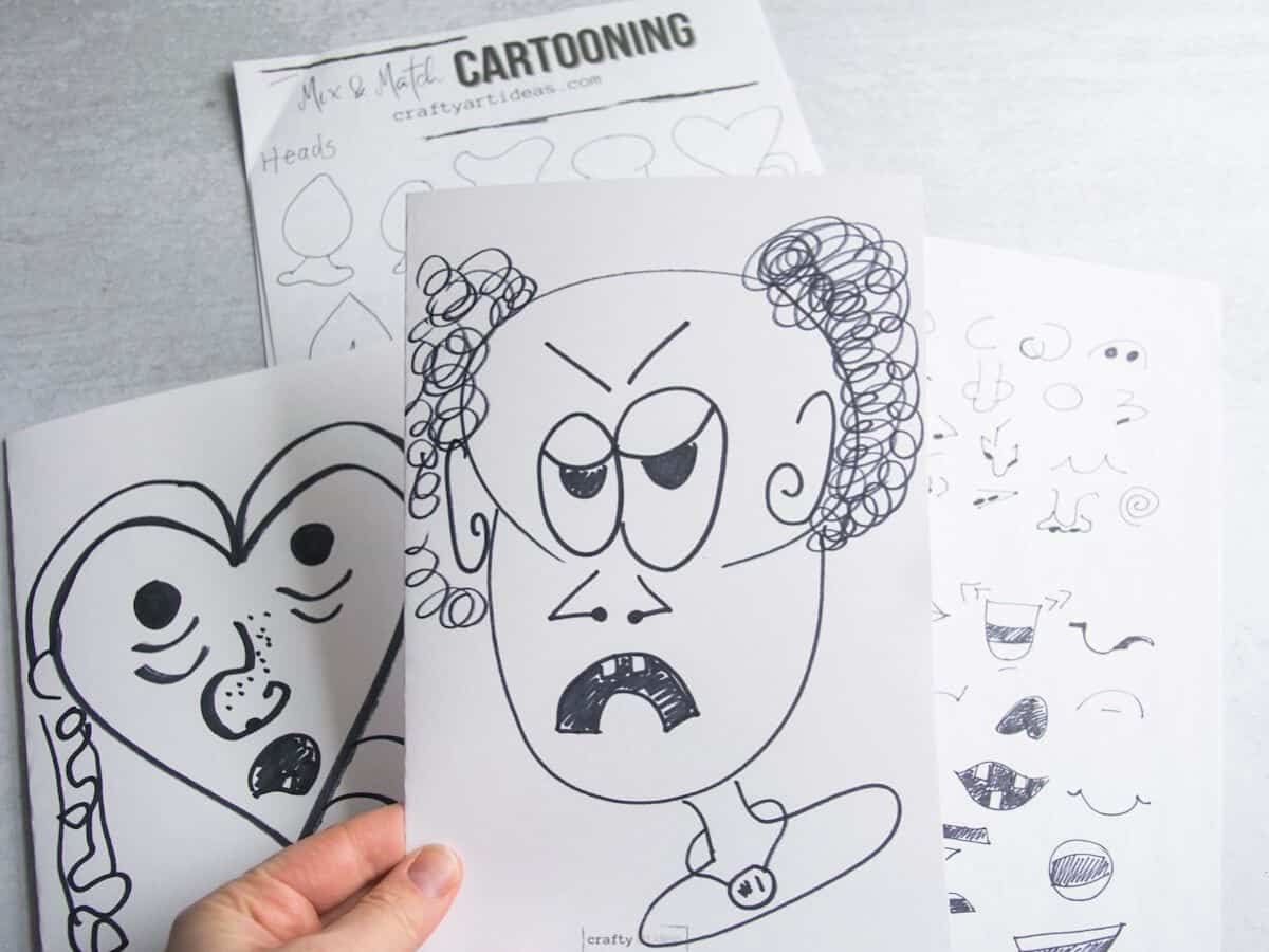 hand holding finished black and white cartoon character head with packet and another cartoon in the background.