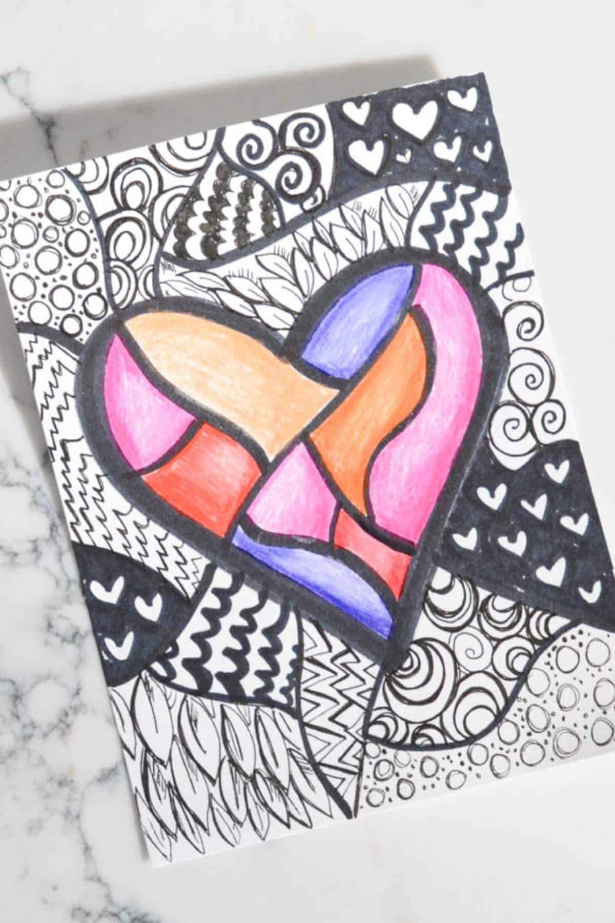 colored pencil and black marker heart drawing on white paper.