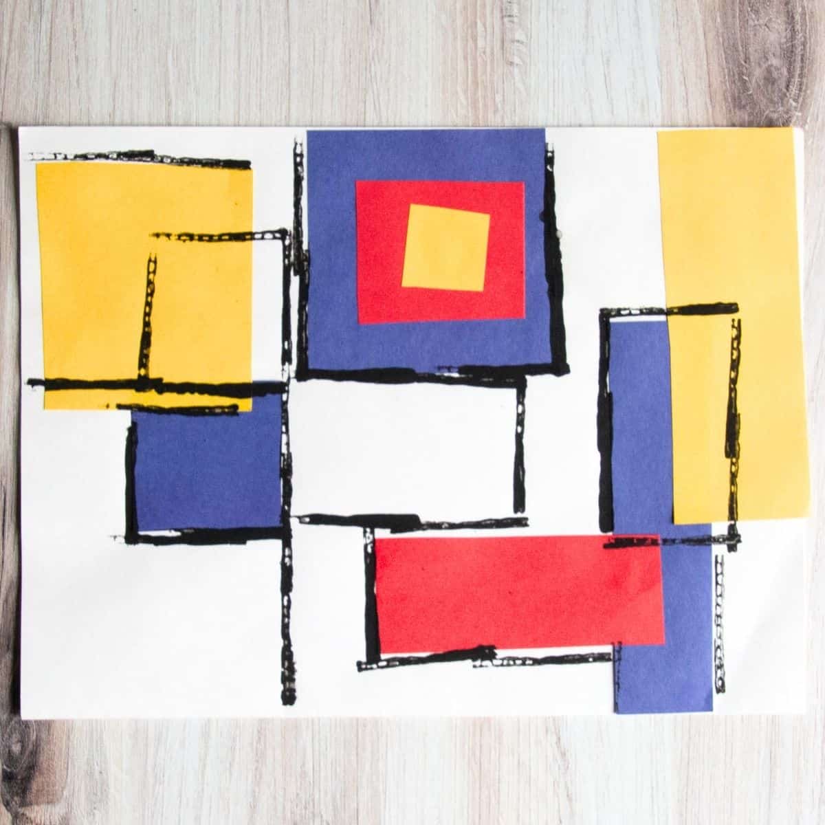 Blue, red, and yellow paper squares with black lines.