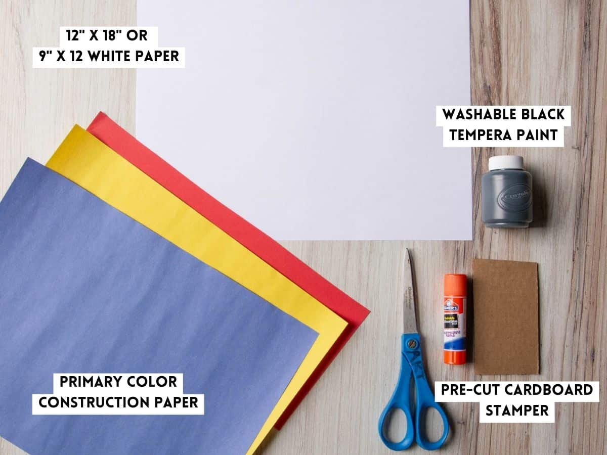 white paper, construction paper and glue stick on a table.