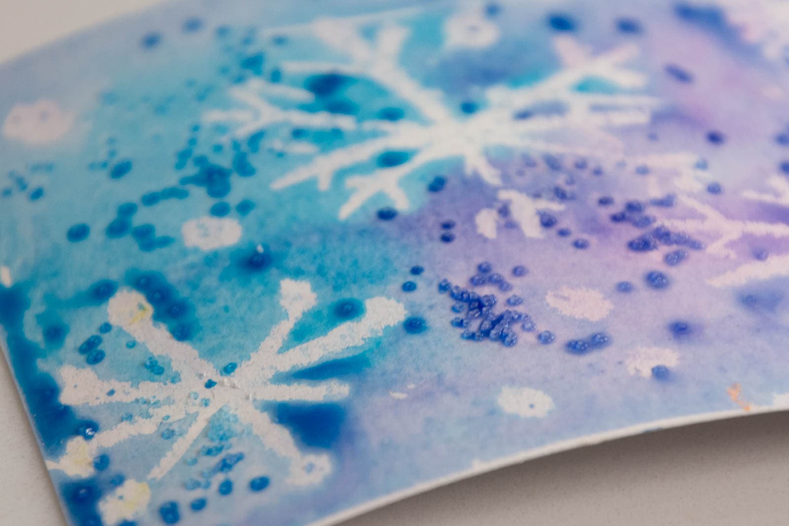 salt on watercolor painting with white snowflakes.