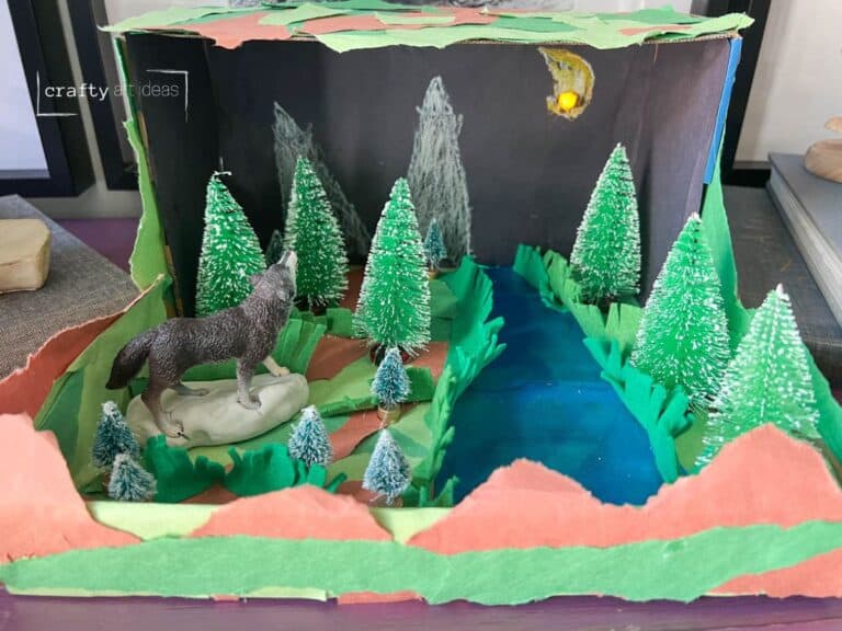 wolf animal habitat diorama in a shoe box with fake trees and wolf figurine.