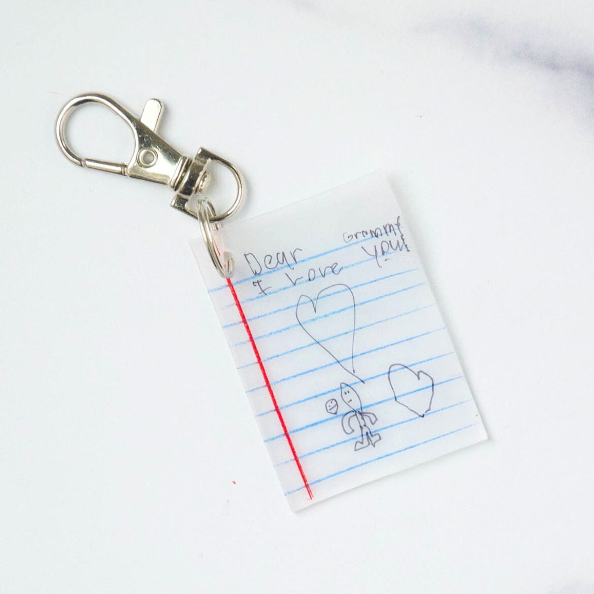 notebook paper keychain with kids writing and drawing.