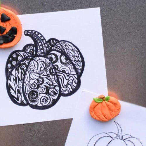 pumpkin drawings being held up with pumpkin clay magnets.