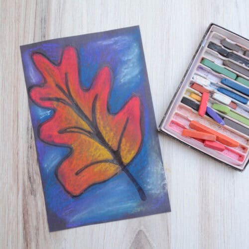leaf chalk pastel drawing and set of chalk pastels on a table.