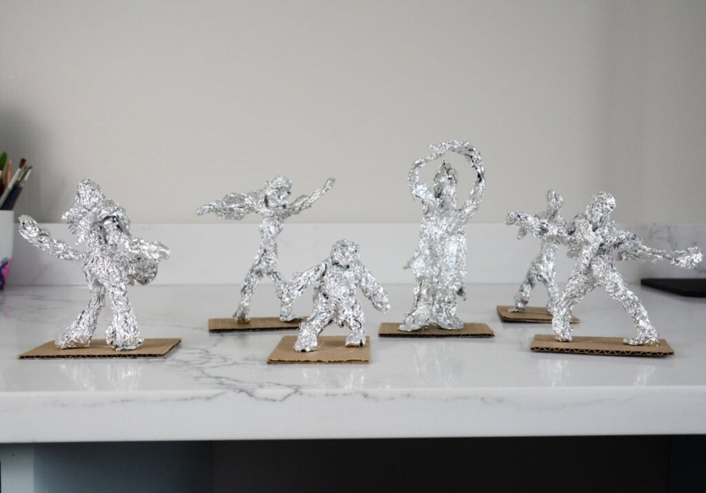 tin foil people sculptures on cardboard bases.