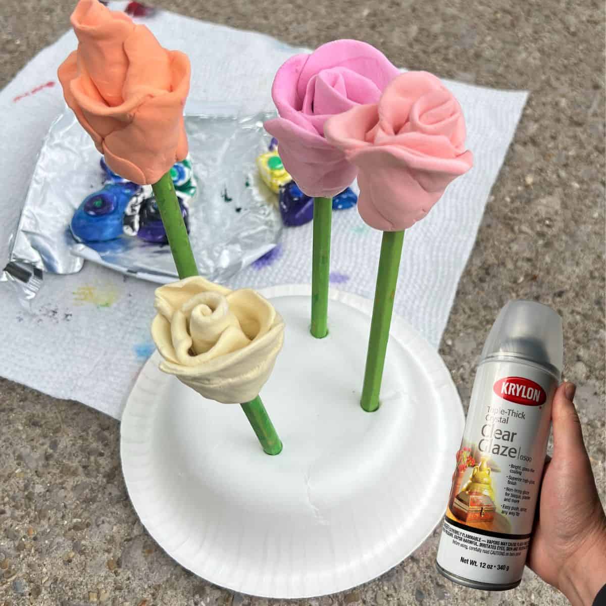 rose craft with hand holding clear glaze spray.