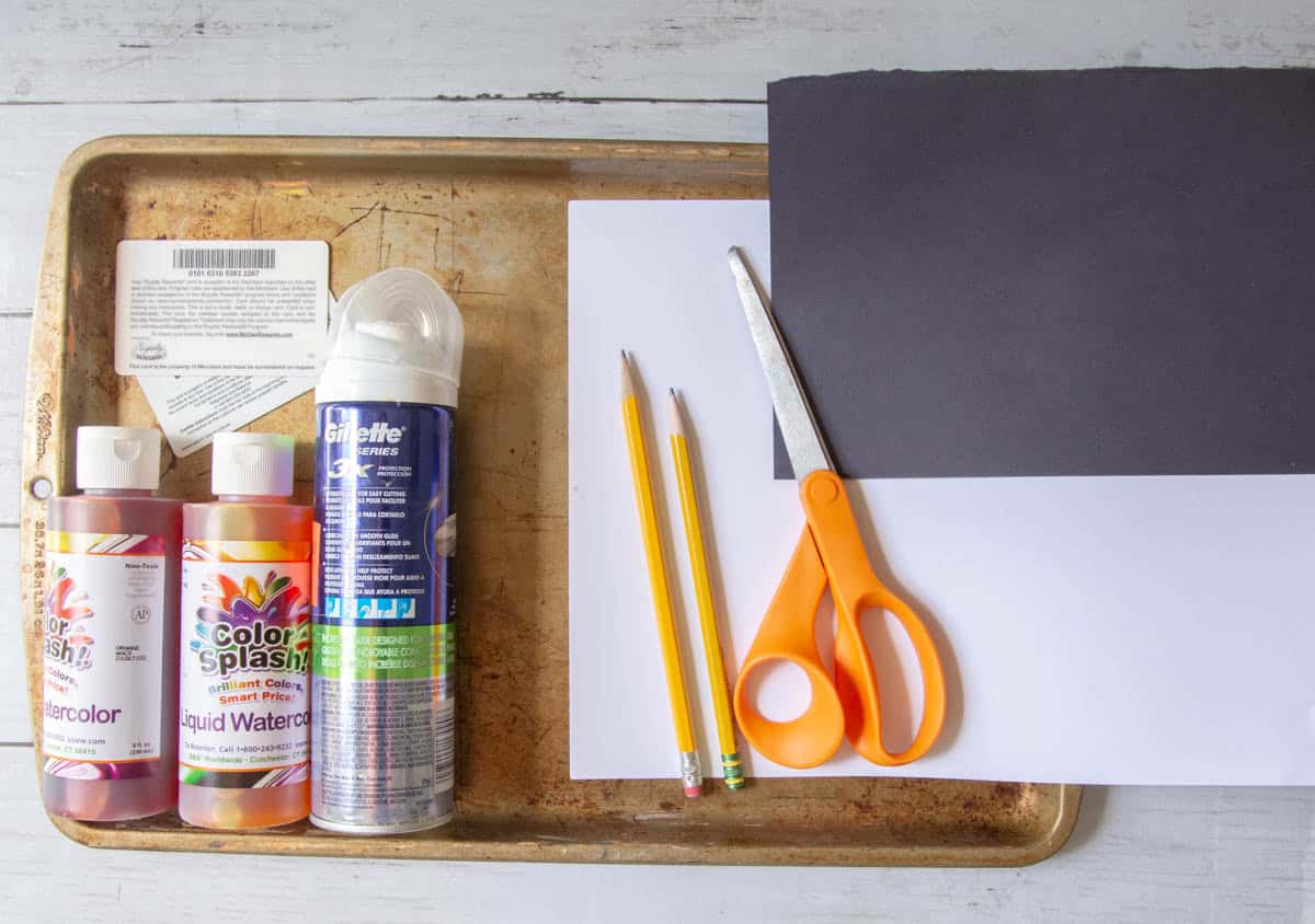 scissors, shaving cream, liquid watercolor paint on a baking sheet.