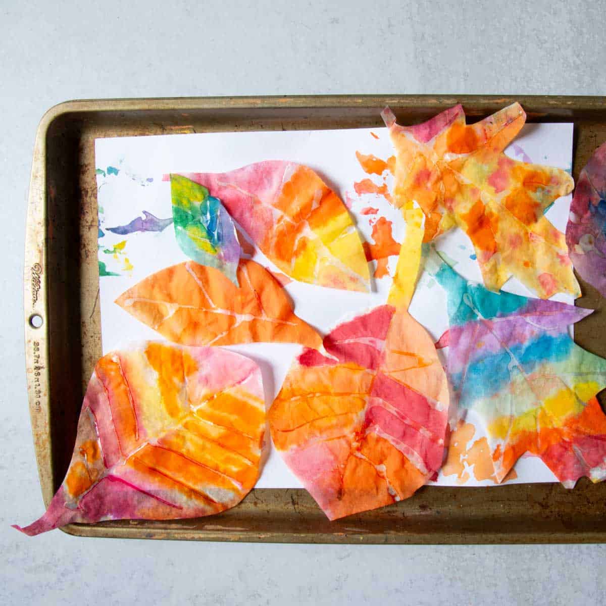 painted coffee filter leaves on tray.