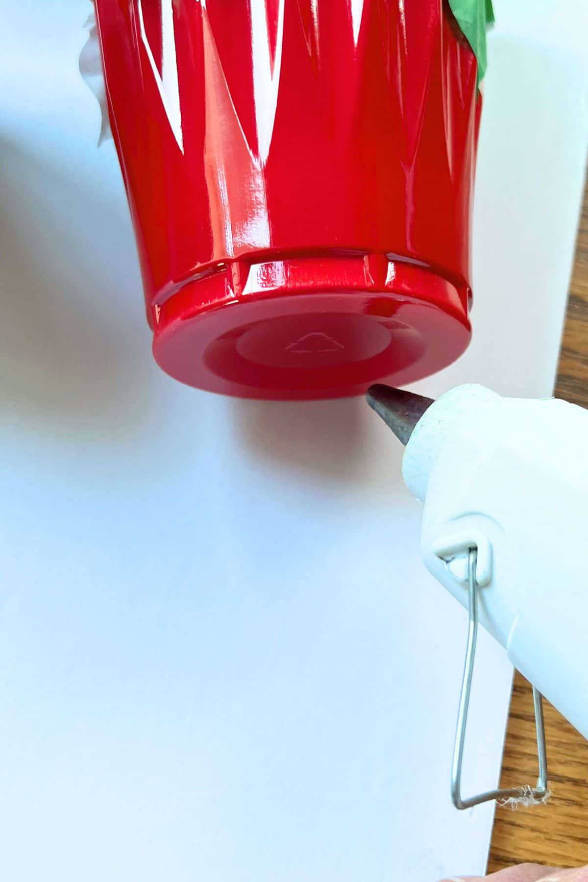 glue gun and red plastic cup on foam core board.