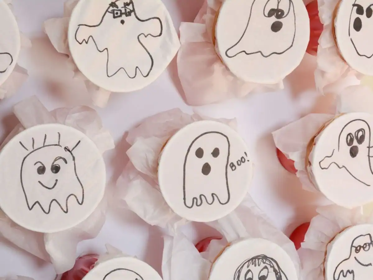 ghosts drawn on white tissue paper wrapped around cups.