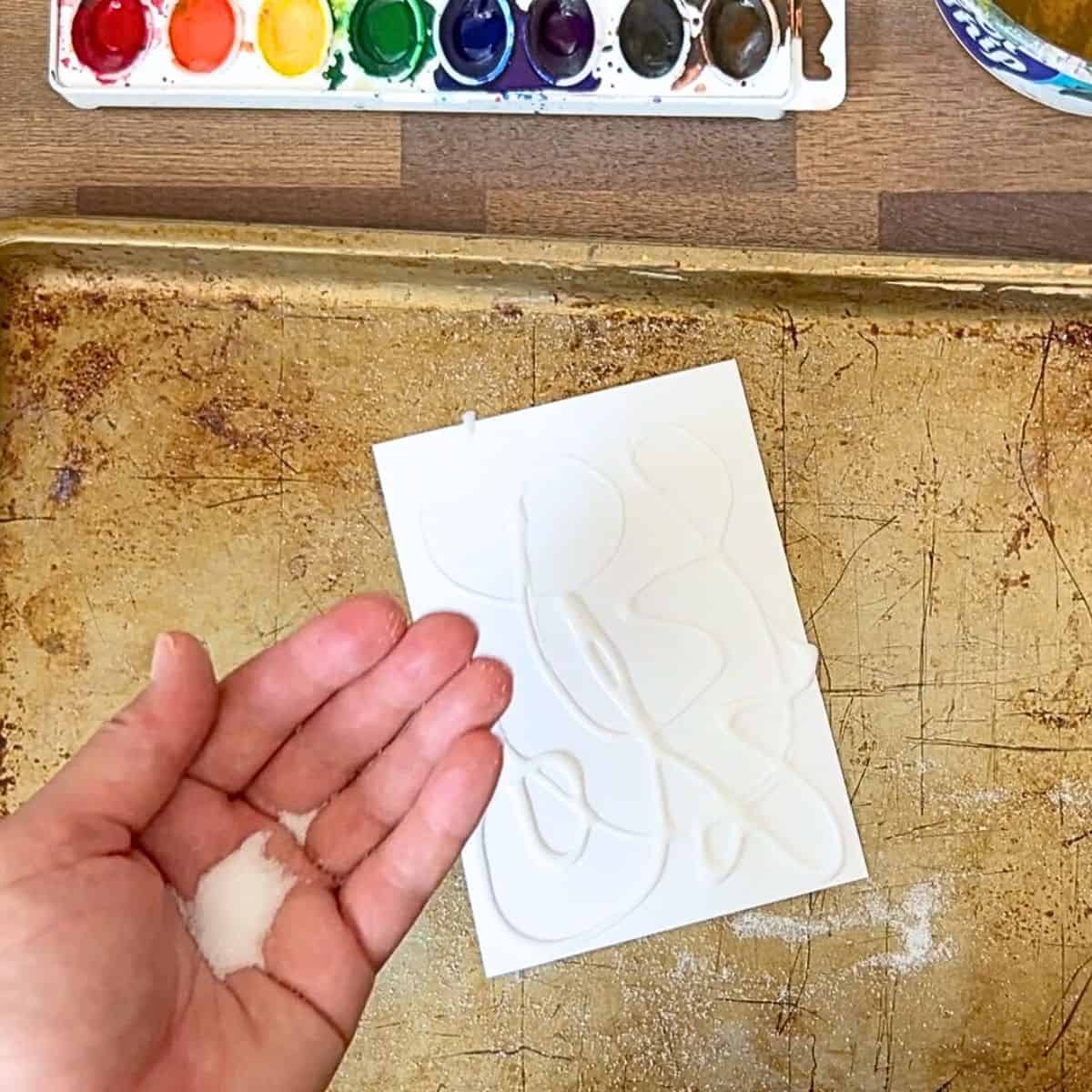 hand holding salt above glue drawing.