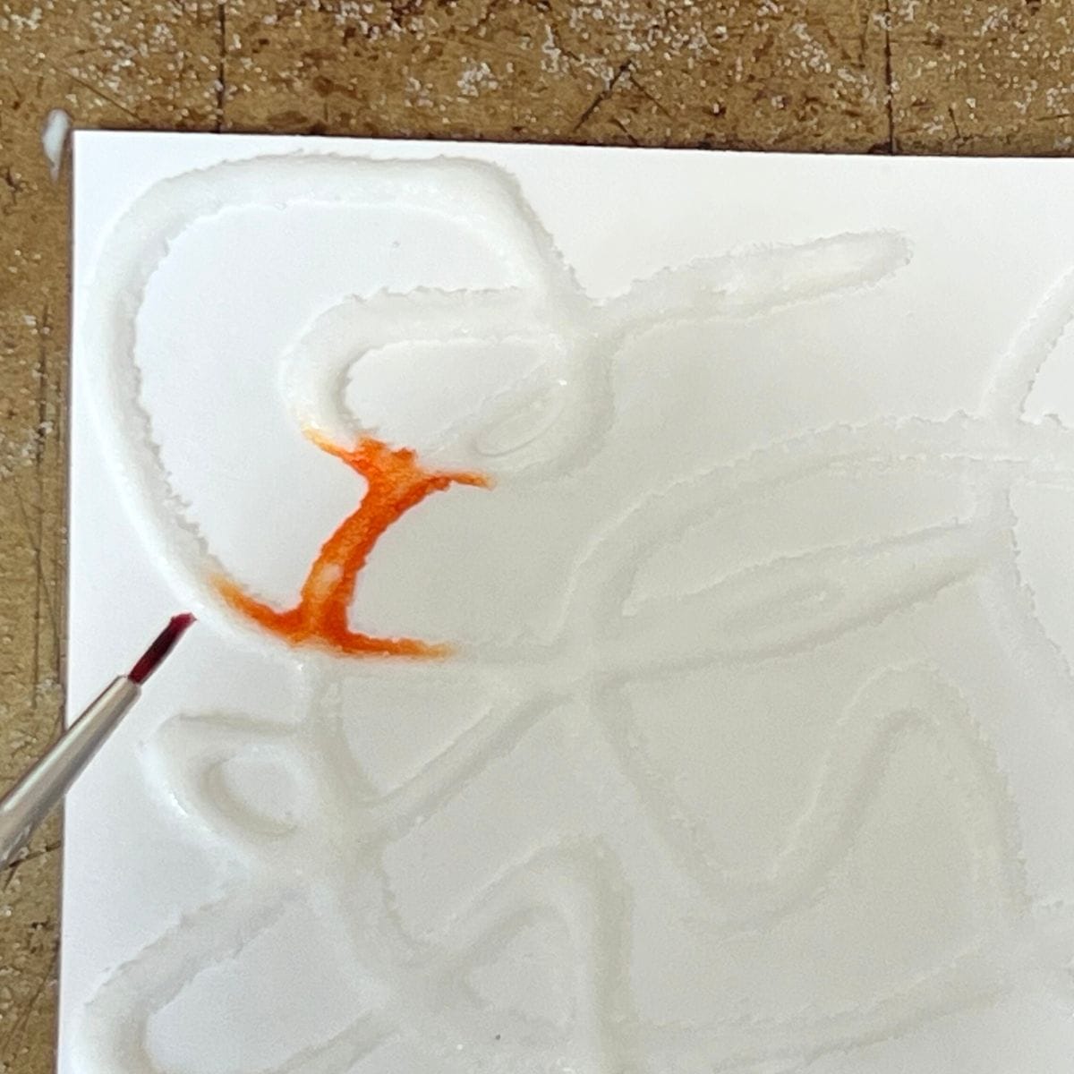 small brush adding color to salt painting.