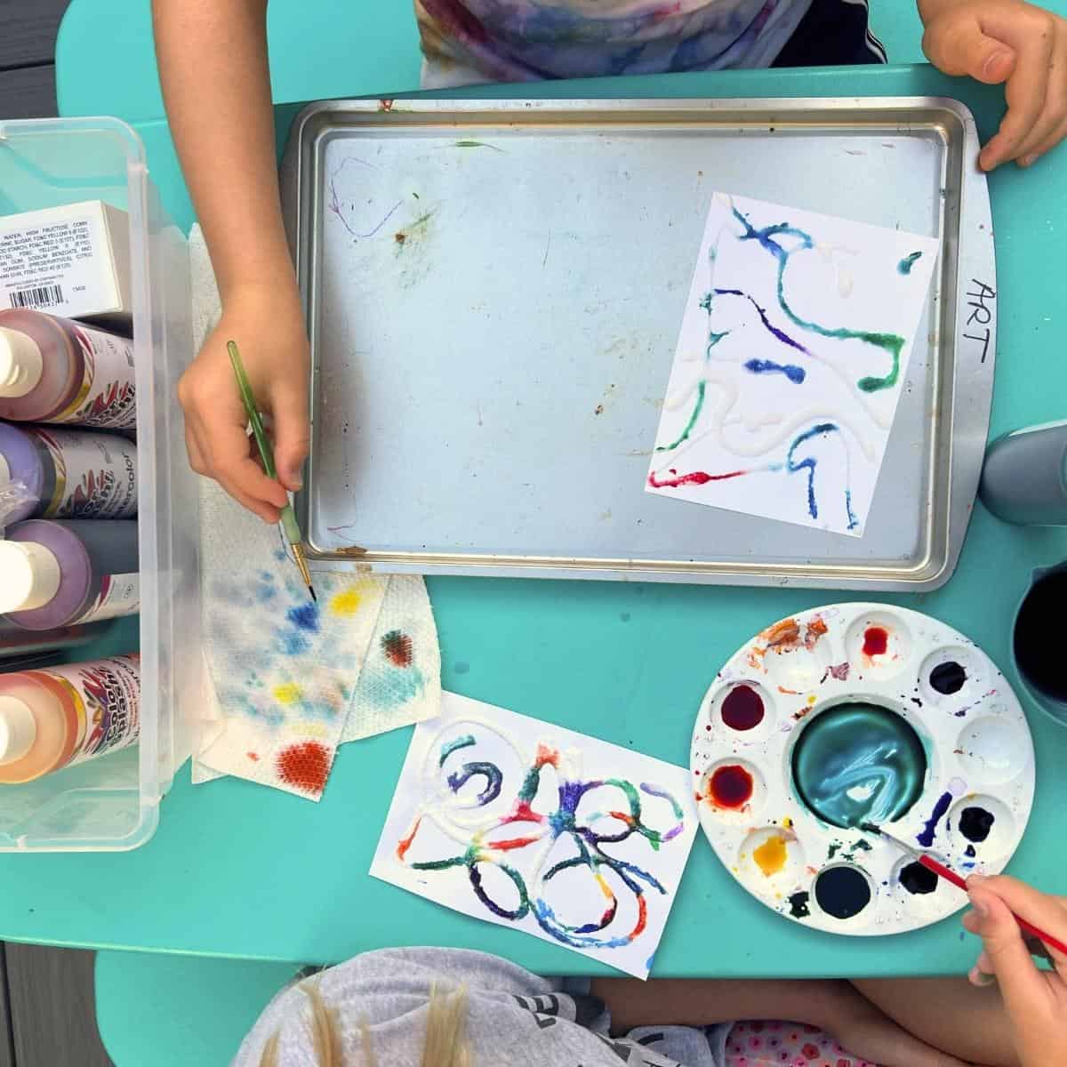kids working on salt painting outside.