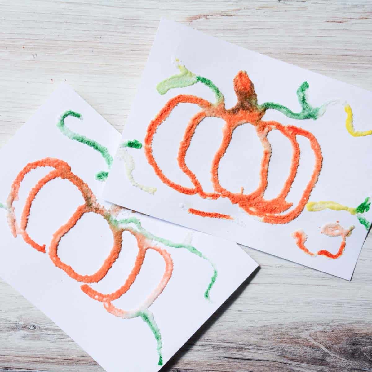 pumpkin salt paintings on wood table.