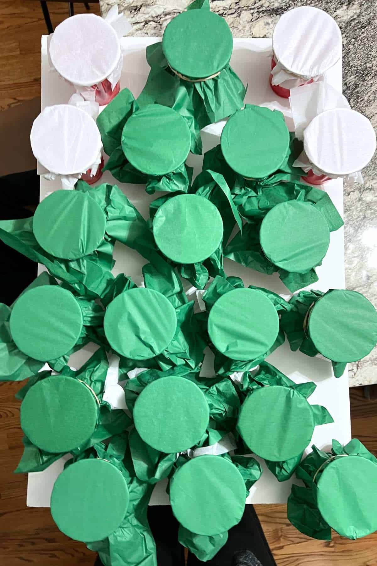 Green tissue paper cups and white tissue paper cups glued on board.