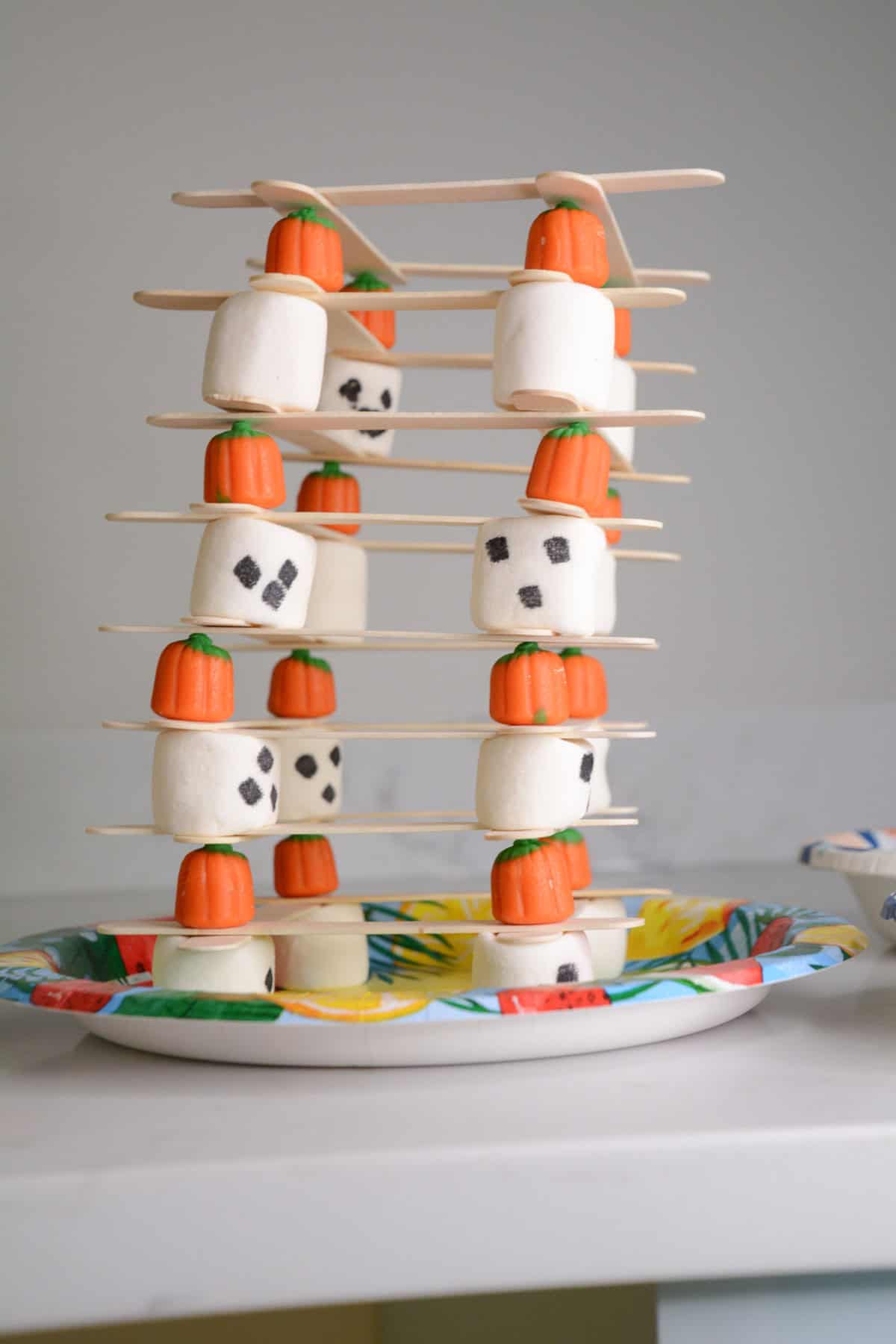 candy pumpkins, marshmallows and popsicle sticks stacked.