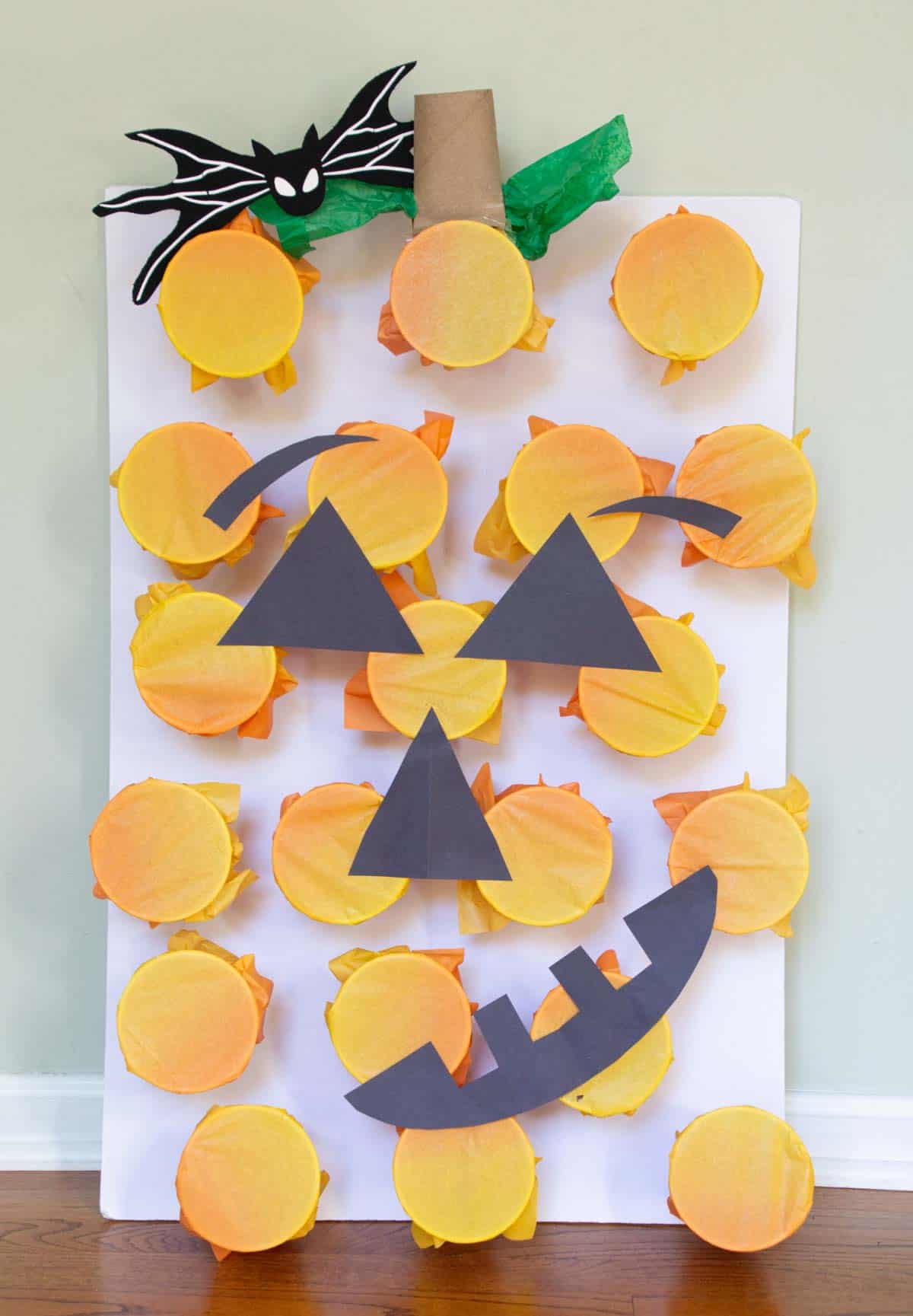 Poke-a-pumpkin cup game with jack-o-lantern face.