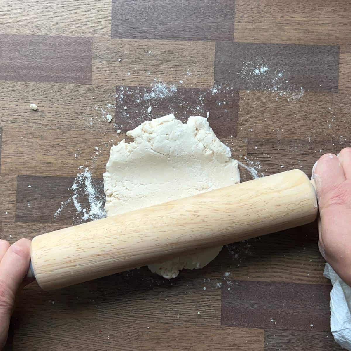 hands using rolling pin on salt dough.