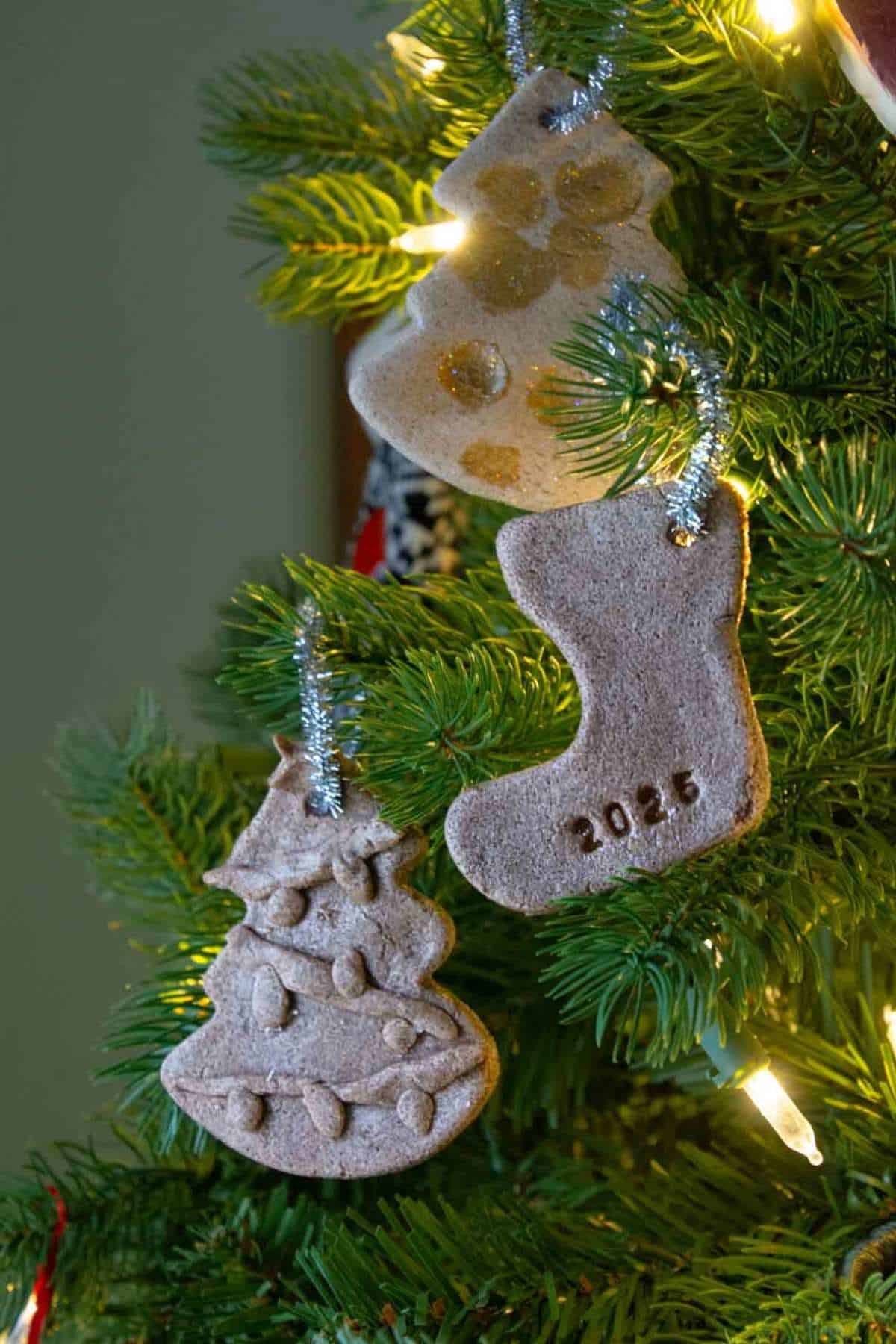 cinnamon salt dough Christmas ornaments hanging on a tree with lights.