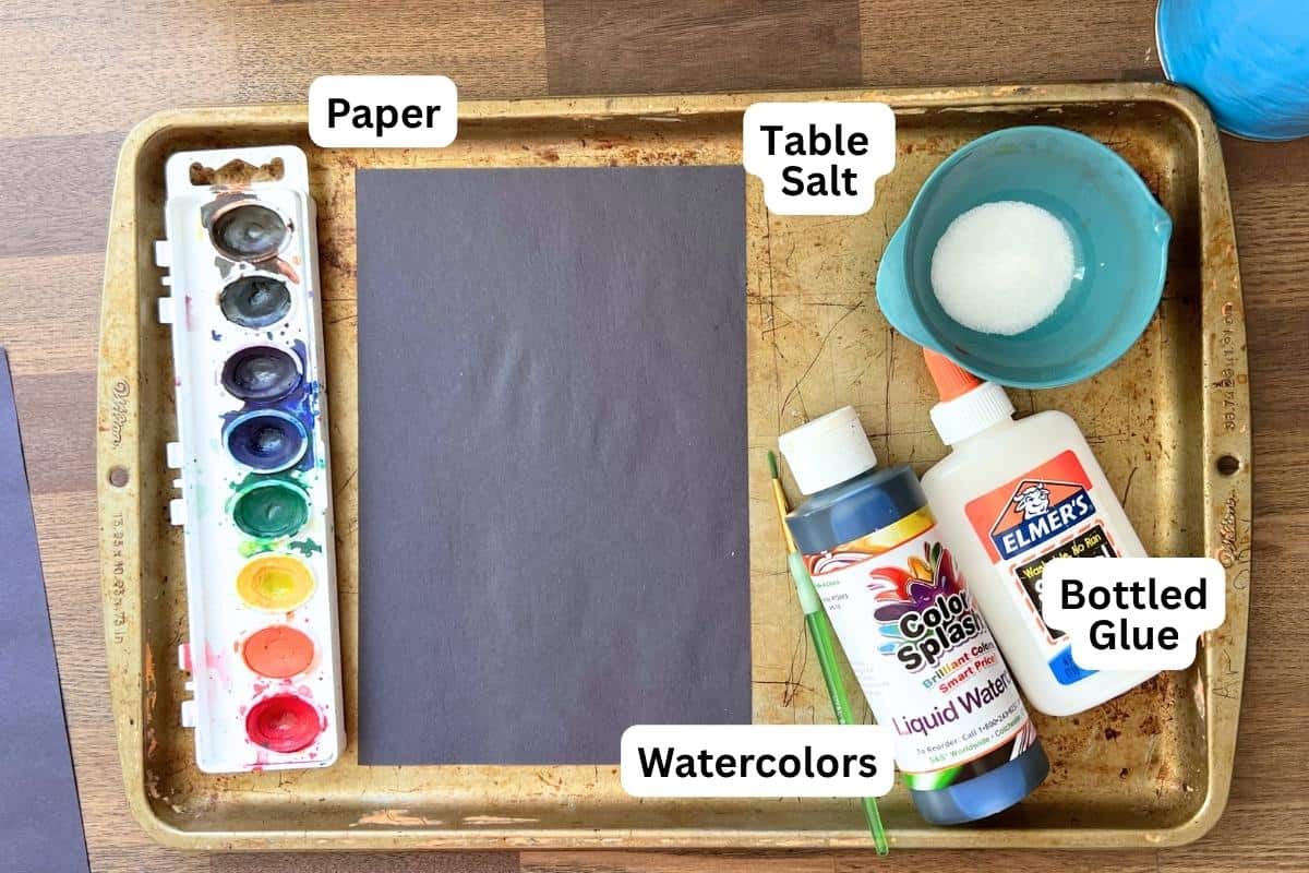 supplies on baking sheet, paper, watercolor paint, glue and salt.