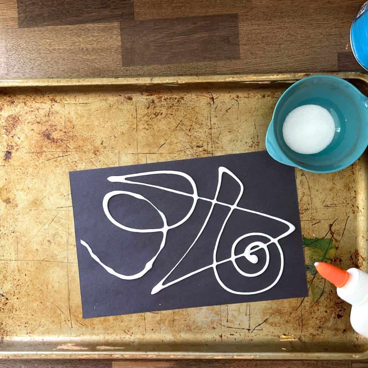 glue bottle lines on black paper.