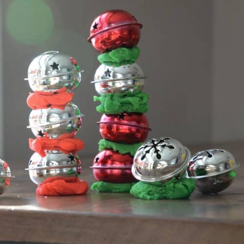 jingle bells stacked in towers with playdough in between.