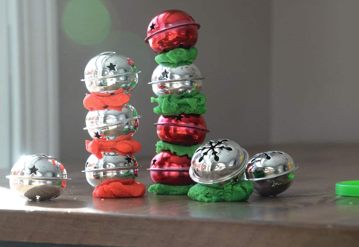 jingle bells stacked in towers with playdough in between.