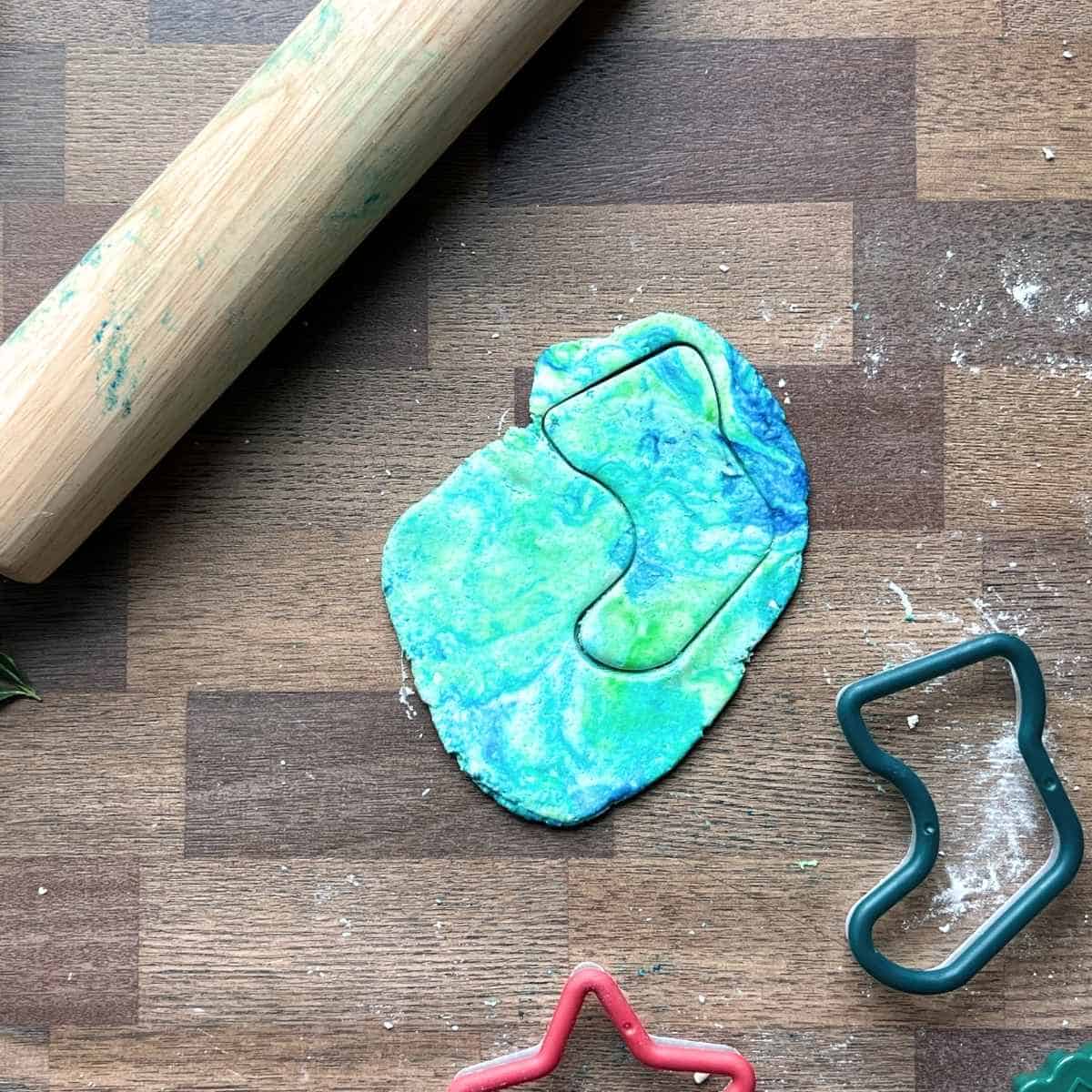 stocking cookie cutter cutting marbled dough.